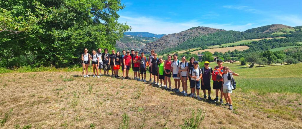 Gruppo di ragazzi in un paesaggio naturale durante un&rsquo;attivit&agrave; educativa all&rsquo;aperto.