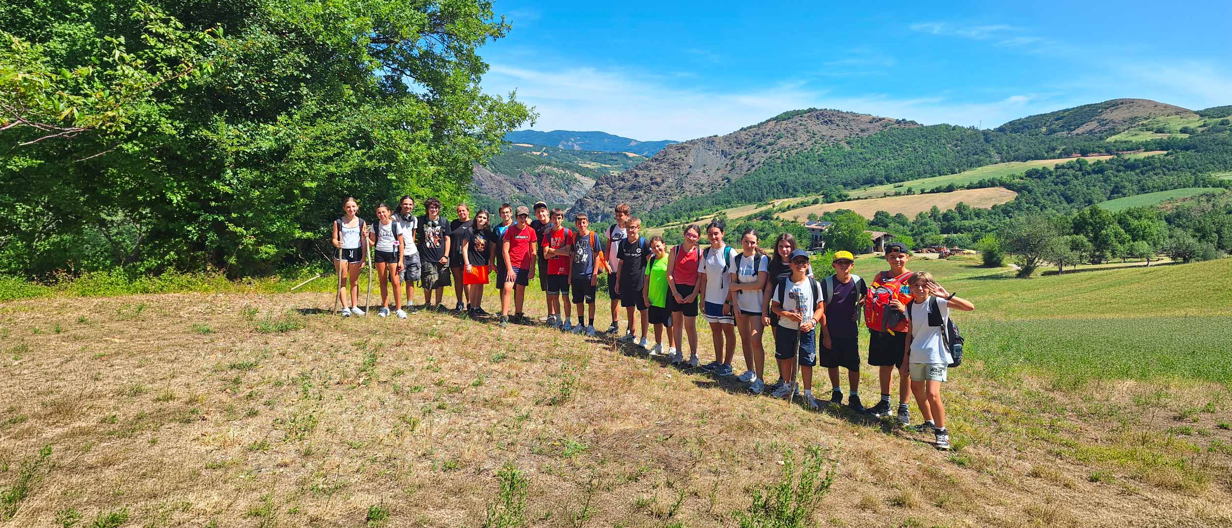 Gruppo di ragazzi in un paesaggio naturale durante un&rsquo;attivit&agrave; educativa all&rsquo;aperto.