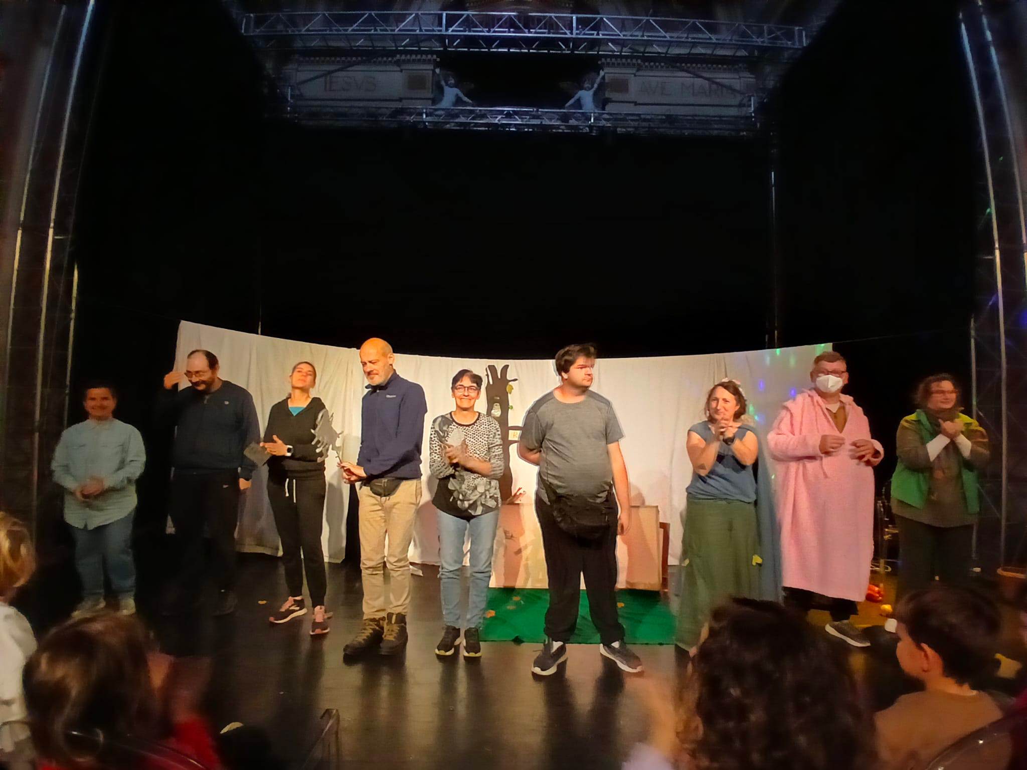 La compagnia Giù i gomiti dal tavolo sul palco al termine di uno spettacolo di teatro d’ombra.