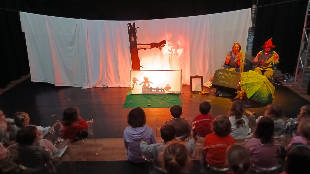 Spettacolo di teatro d’ombra della compagnia Giù i gomiti dal tavolo di Eureka davanti a un pubblico di bambini.
